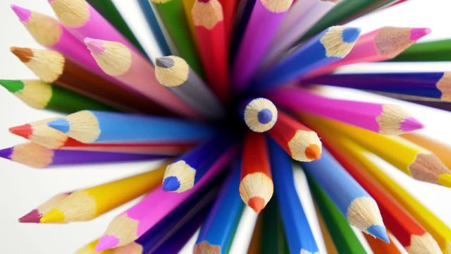 Color pencils turning on a white background. Close up. 4K UHD.