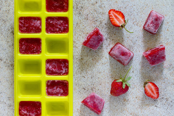 Ice made from strawberries for summer drinks with copy space on