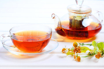 Tea teapot cup herbal wood background
