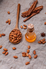Bottle of extra virgin almonds oil with whole almonds and cinnam