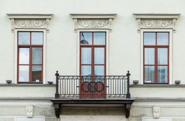 Three windows in a row and balcony on facade of urban apartment building front view, St....