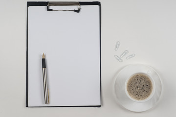 Business blank, notepad,  coffee cup and pen at office desk table top view. Corporate stationery branding mock-up