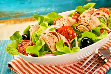Fresh tuna salad with lettuce, olives and tomato