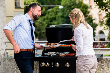 Büro Kollegen grillen Würstchen auf Grill nach Feierabend auf Terrasse