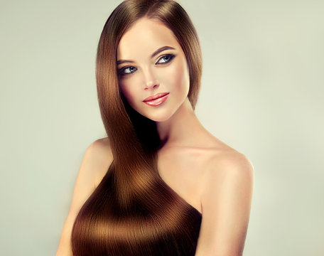 Beautiful brunette girl with long straight smooth hair . A woman with healthy straight hairstyle
