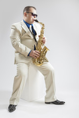 Fototapeta premium Music Concepts. Hadnsome Male Saxophone Player Playing in Studio