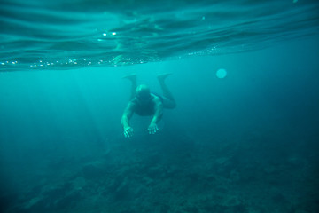 man swim underwater sea