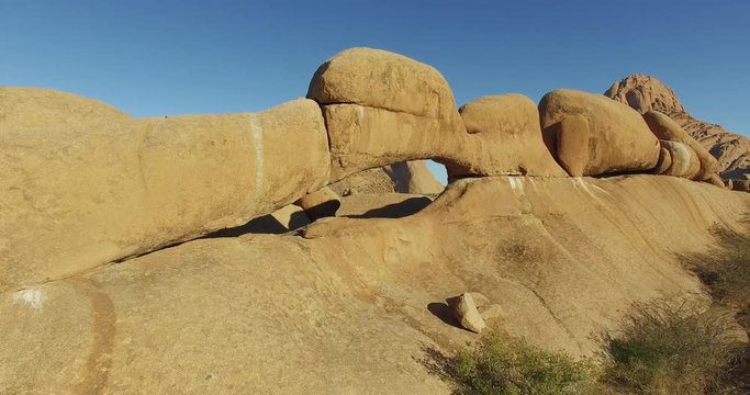 4K aerial shot flying through the granite arch of the Spitzkoppe mountains