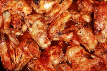 
Several freshly baked chicken wings on a baking pan