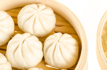 Fototapeta na wymiar Chinese steamed buns in bamboo steamer basket isolated on white