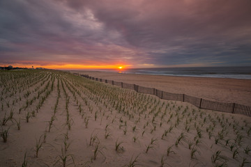 Sunrise over teh Atlantic ocean with fence and beach