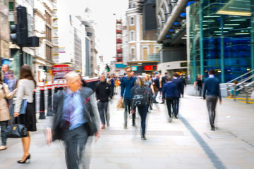 Business people walk through the City of London street. Blurred image. City of London business life concept 