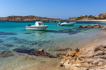 Fototapeta na wymiar Small boat in Paranga Beach on the island of Mykonos, Cyclades, Greece