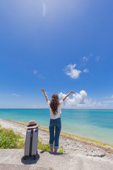 沖縄の海と旅をする女性