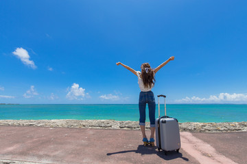 沖縄の海と旅をする女性