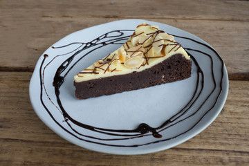Brownie cheesecake on round blue plate on wooden table