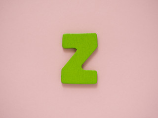 Capital letter Z. Green letter Z from wood on pink background.