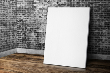 Blank white canvas frame leaning at grunge brick wall and wood f
