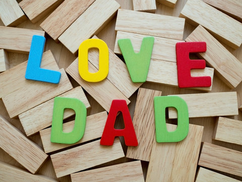 Love dad. Happy Father's Day celebrations. Love dad word from colorful of wood on wooden block in background. Father's day.