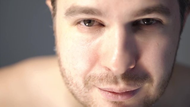Young man with short beard leaning towards the camera