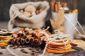 Dry orange and lemon, coffee beans in the bag, cinnamon on wooden brown background.