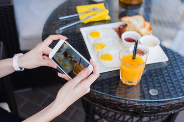 Woman hands taking food photo by mobile phone. Food photography. Delicious breakfast.