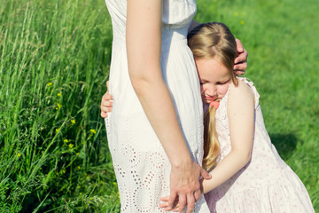 Little Girl In Meadow Field Embracing Her Mother 