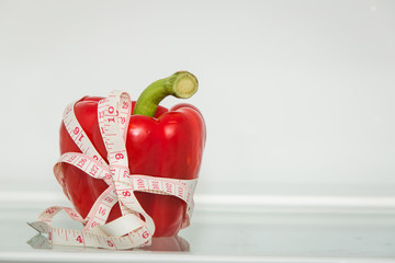 Red sweet pepper with measuring tape. Healthy eating. Healthy lifestyle. Diet. Source of vitamins....