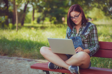 Young girl with a laptop on nature