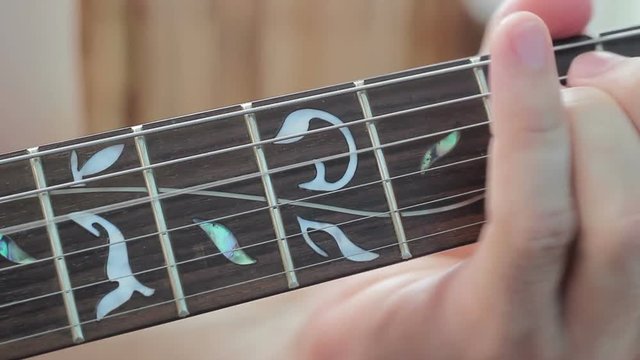 Playing electric guitar fingerboard fingers of his left hand