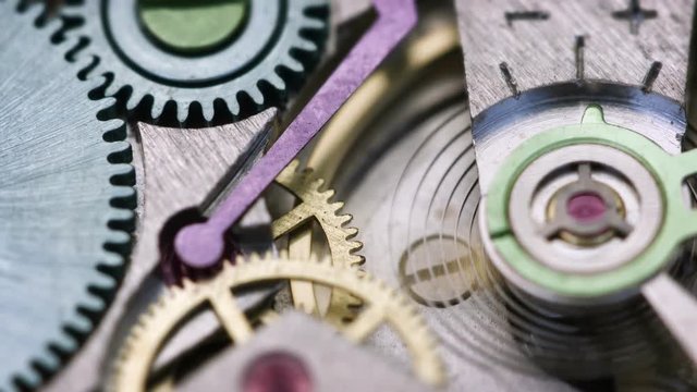 4k video - Closeup view of a clockwork spring and flywheel inside a watch casing. Fully functioning parts are spinning and oscillating as designed.