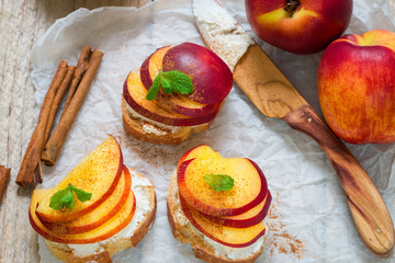 Healthy Breakfast. Bruschetta with peach,nectarine, cottage cheese, cinnamon and mint. Selective focus
