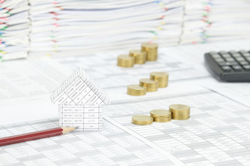 House with pencil have blur step gold coins as background