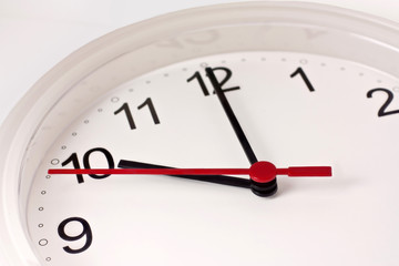 Time concept: closeup of typical white office clock on white
