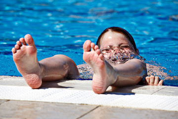 Children's feet in a spray of water in the pool