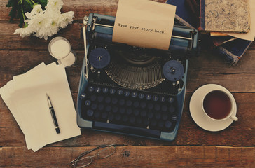 Vintage black typewriter on decorated wooden table, outdoors, close up - Powered by Adobe