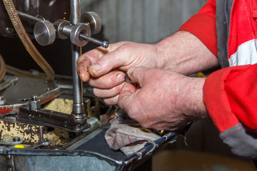 Professional mechanics testing diesel injector in his workshop,