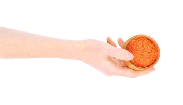 Hand Holding Wooden Bowl With Powdered Paprika Isolated On White