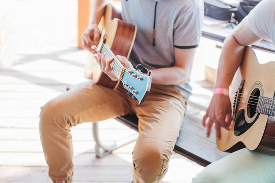 Two friends playing guitars.