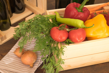 Fresh market vegetables in the wood box with objects in the background
