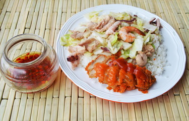 stir fried cabbage with seafood and crispy chicken on rice