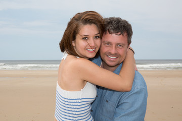 Fototapeta na wymiar Cheerful couple laughing together at the beach