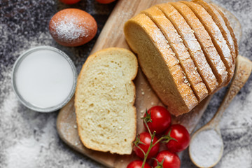 Ingredients for the preparation of bakery products. Bread, flour, eggs and cherry tomatoes.