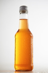 Transparent glass sealed bottle isolated on simple background in center and tasty drink inside mockup