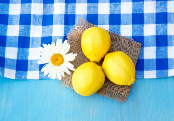 Fresh lemons and camomile on wooden table