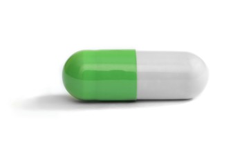 Green and white colored pill on white background