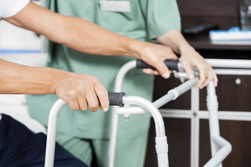 Patient's Hands Holding Walker By Nurse In Rehab Center