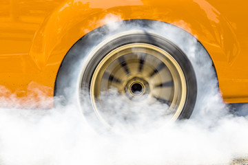 Drag racing car burns rubber off its tire in preparation for the race