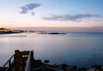 Photo of sea in protaras, cyprus island, with rocks and hotels at sunset.