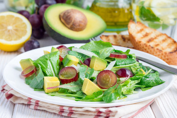 Vegetarian salad with avocado, grape, rucola, onion, vinegar dressing